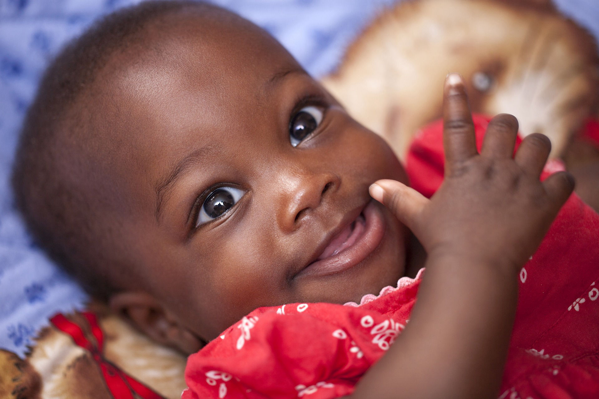 African American baby girl in red dress on a blanket