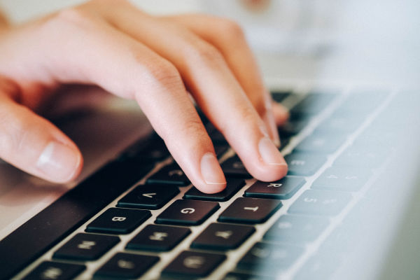 closeup of adult hand on a computer keyboard